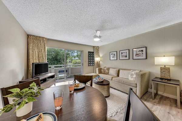 Dining Area and Living Room with Sofa, TV Console, and Balcony View