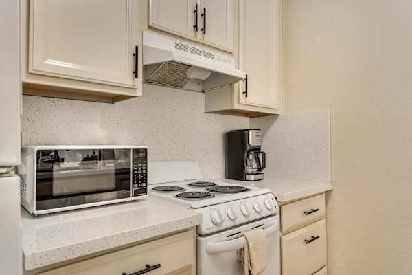 Kitchen Setup with Electric Stove, Microwave, and Coffee Maker