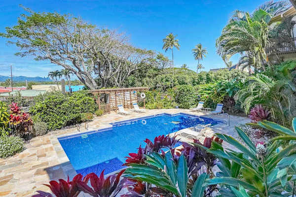 Resort-style pool surrounded by lush tropical gardens