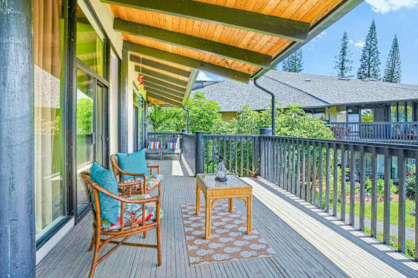 Covered lanai with outdoor seating overlooking the greenery