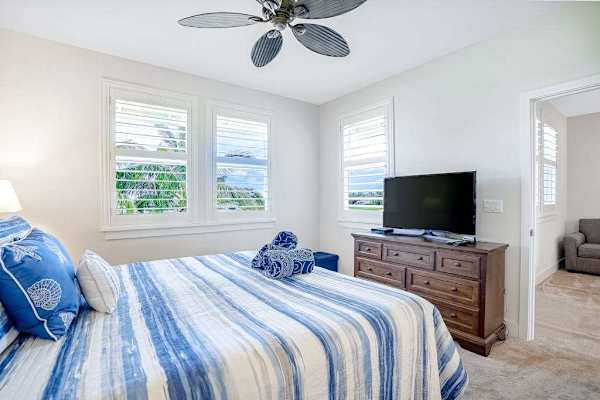 Master bedroom with king bed, ceiling fan and flat screen tv. 