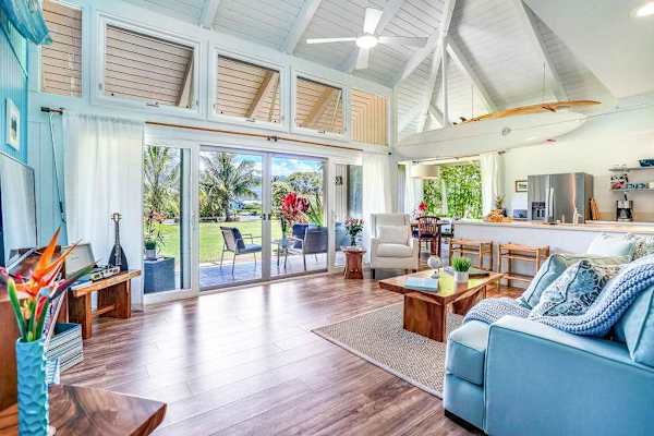 Open-concept living room with vaulted ceilings and lanai access.