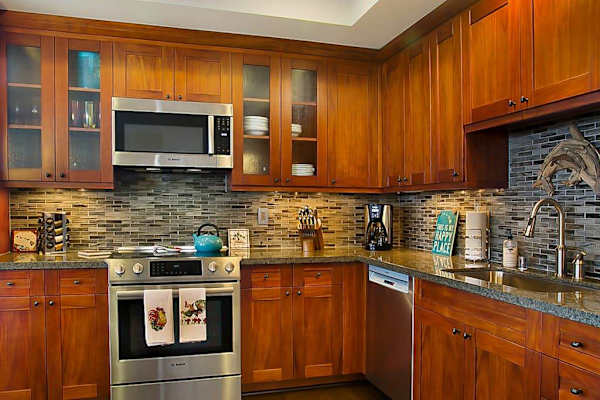High-end and high-style, the open kitchen boasts handsome cherry cabinets, granite counters, stainless appliances, and a large island with seating for three. 