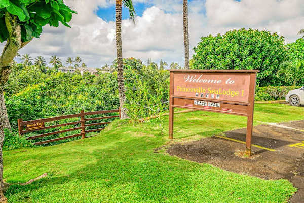 Welcome entrance sign surrounded by lush tropical greenery at Sealodge