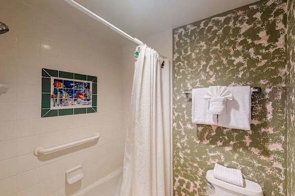 Patterned shower wall and fresh towels brighten this bathroom beautifully