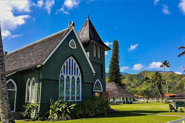 Historic island church stands beside manicured lawns under clear skies