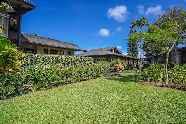 Lush, manicured front yard with vibrant island greenery