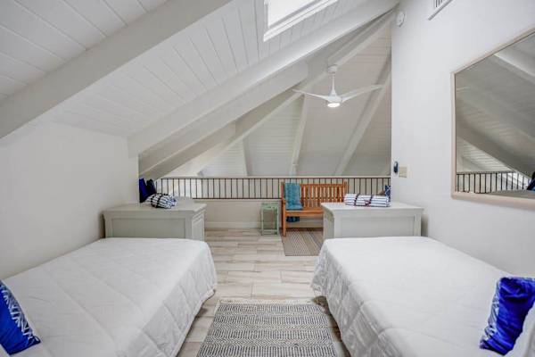 Cozy loft bedroom with two twin beds and vaulted ceilings.