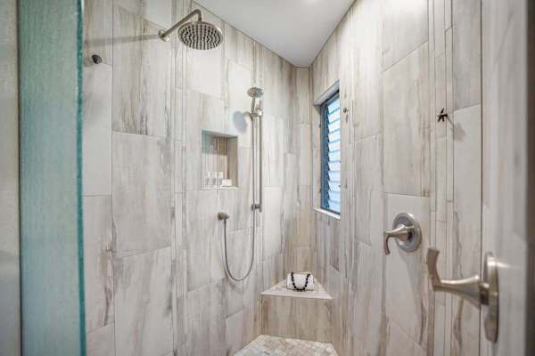 Walk-in shower with beautiful tilework and modern fixtures.