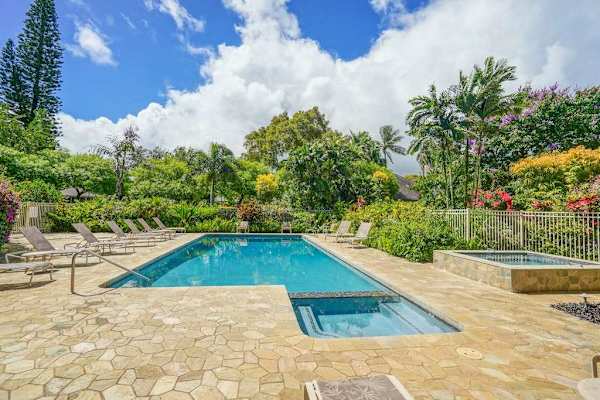 Swimming pool provides refreshing enjoyment beside palms and landscaped grounds