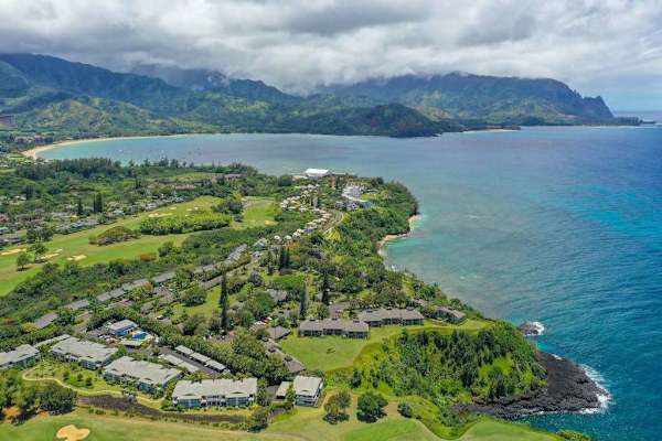 Elevated landscape reveals winding roads, green valleys, and island residences