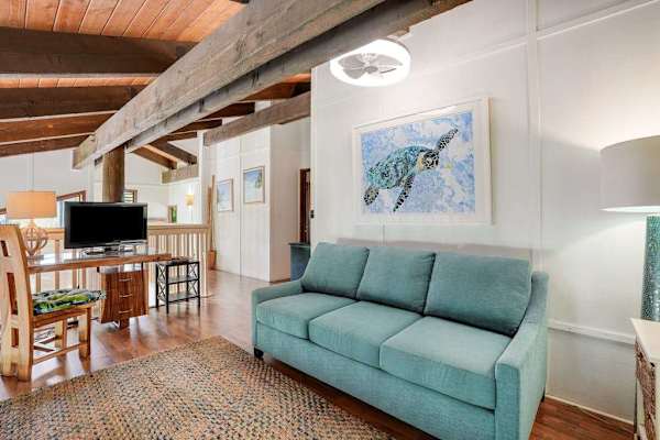 Spacious loft area featuring a sofa bed and flat-screen TV, ideal for additional guests to relax.