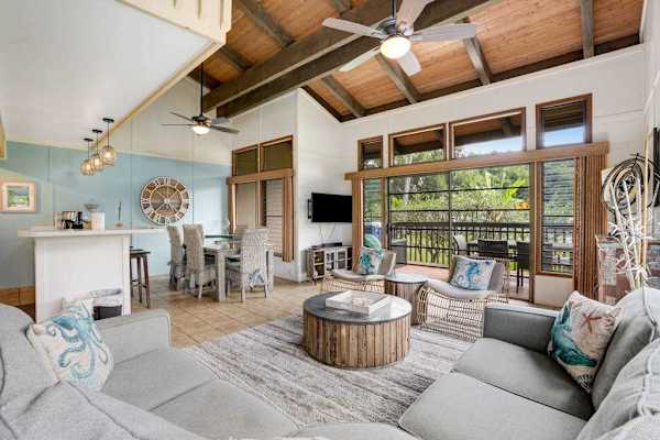 Spacious living room bathed in natural light, featuring comfortable seating and a flat-screen TV for cozy nights in.