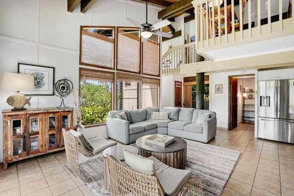 Spacious living room bathed in natural light, featuring comfortable seating and a flat-screen TV for cozy nights in.