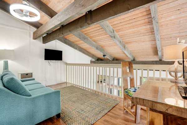 Spacious loft area featuring a sofa bed and flat-screen TV, ideal for additional guests to relax.