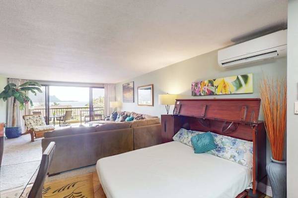 Queen bed complements this bright island inspired living room retreat