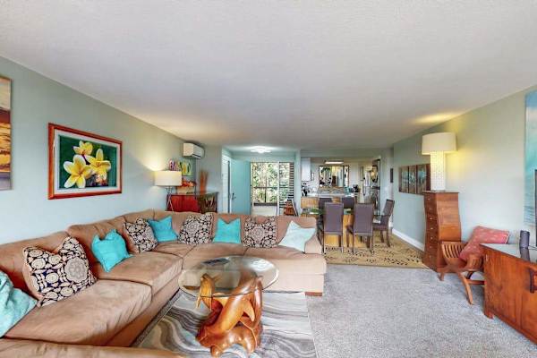 Colorful living room pairs cozy seating with cheerful island artwork