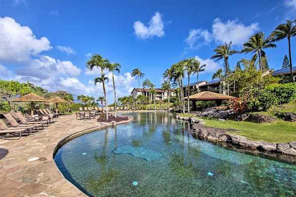 Lagoon-style pool features clear waters, palm trees, and inviting seating