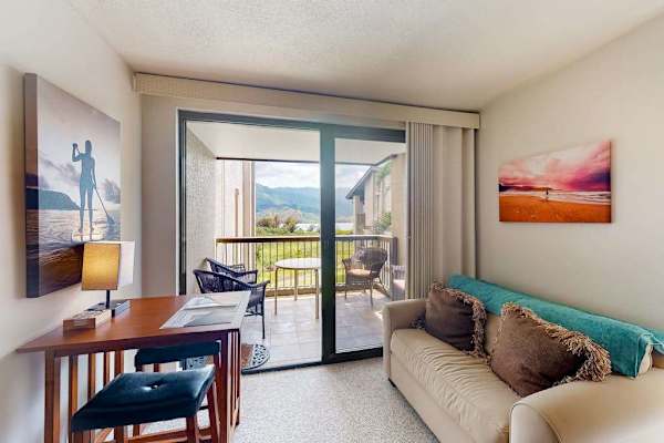 Living area features dining space, balcony access, and comfortable seating