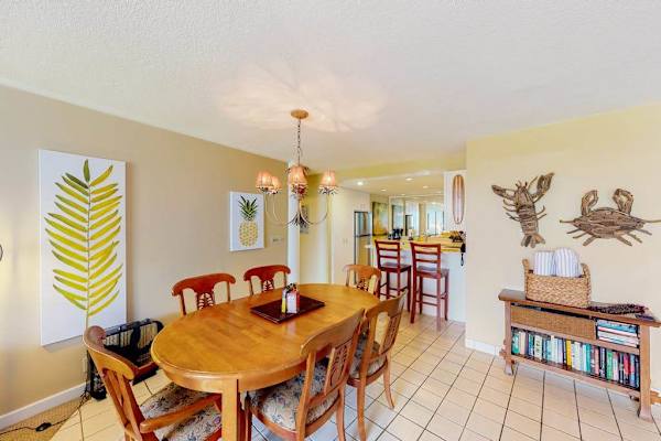 Dining room features round table, artwork, and open living access