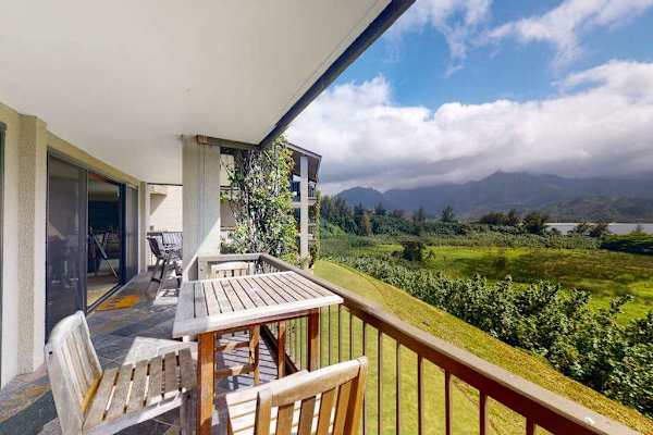 Covered balcony overlooks lush fields, mountain scenery, and tropical landscapes