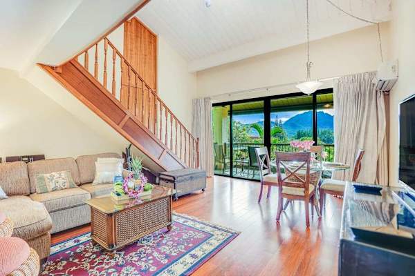 Open-concept living space connects seating, dining, balcony, and beautiful views