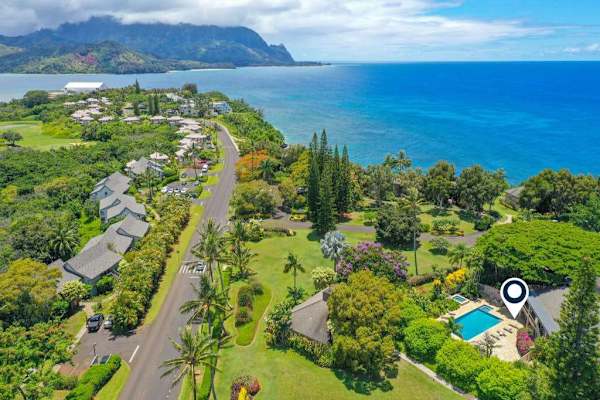 Ocean-view surroundings feature turquoise water, rugged cliffs, and tropical vegetation
