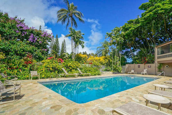 Poolside space features comfortable loungers, clear water, and scenic greenery