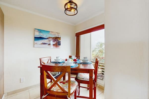 Dining room presents a round table, chairs, and garden views