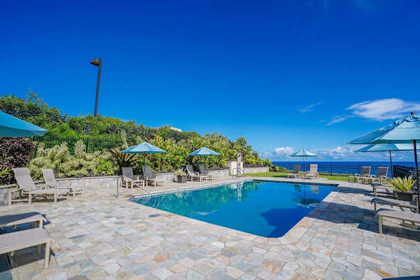Pool area to relax by the water with lounge chairs and umbrellas