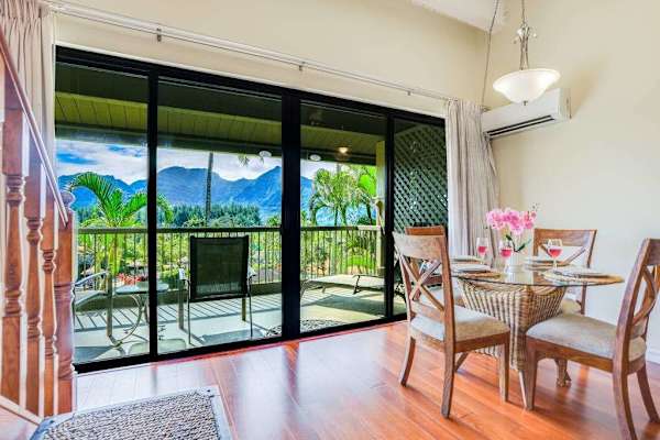 Enjoy morning coffee beside bright windows overlooking lush tropical scenery