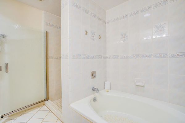 Bright Bathroom featuring Separate Soaking Tub & Glass Enclosed Shower