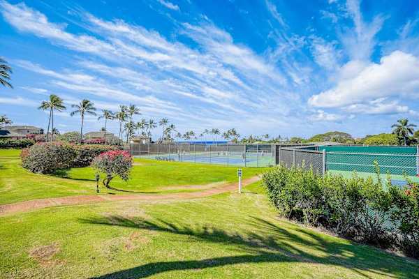 Outdoor Tennis Courts Framed by Landscaping & Blue Skies