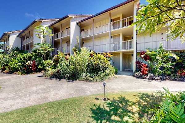 Resort entrance surrounded by lush tropical gardens.
