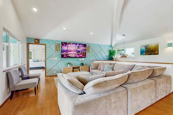 Contemporary living room featuring a prominent, wrap-around beige sectional sofa that maximizes seating space.
