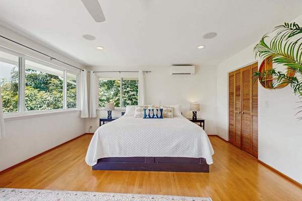 Bright bedroom features a spacious layout with a tropical aesthetic