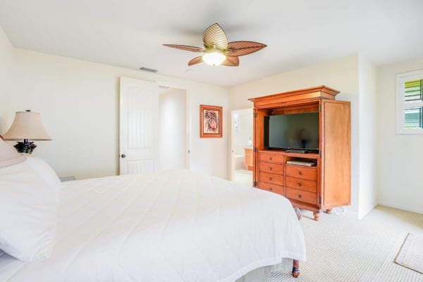 Guest bedroom with flat screen tv and a queen bed.