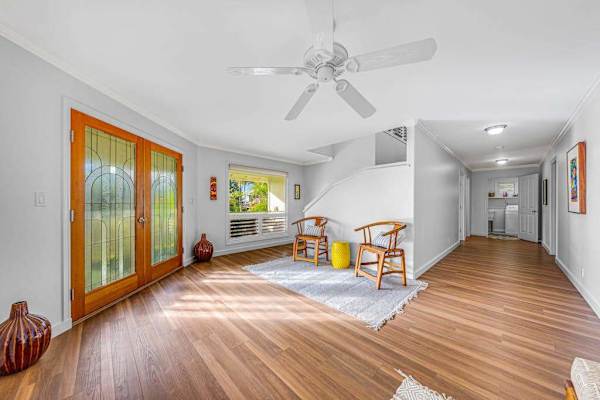 Sunlit open hallway and seating area with hardwood flooring 