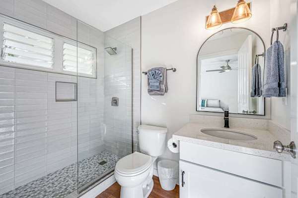 Bright bathroom featuring tiled walk-in shower and single vanity