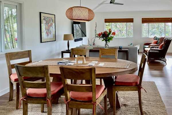 Spacious wooden dining table with seating for six and sunlit garden views