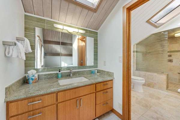 Spacious vanity offers twin sinks beneath warm timber framed mirror