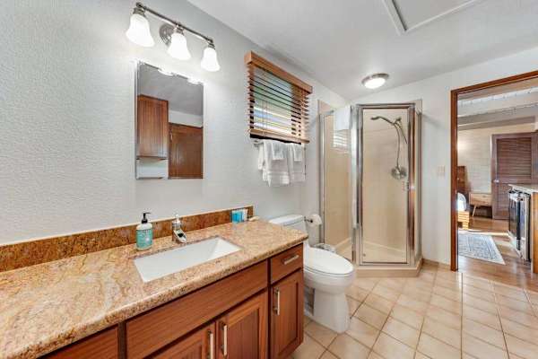 Granite vanity and glass shower create a polished refreshed retreat