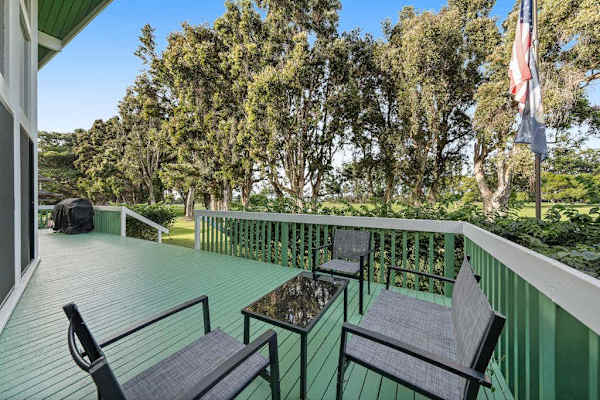 Green patio offers outdoor seating surrounded by towering tropical trees