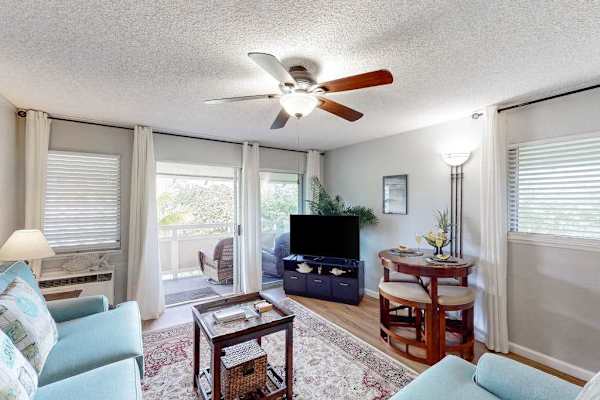 The living area seamlessly opens onto a private lanai with comfortable seating and impressive views of the mountains and surrounding landscape.