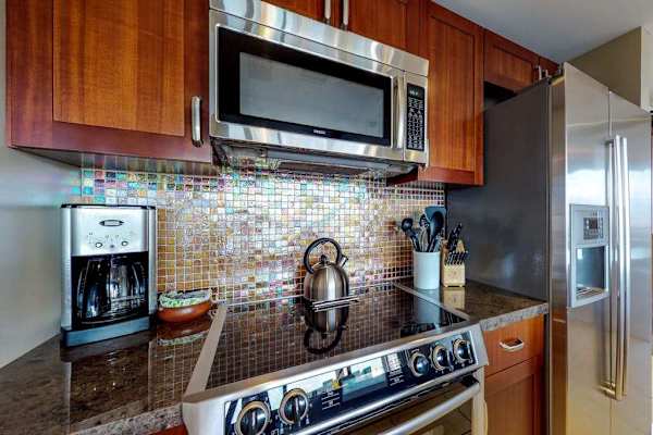 Fully equipped kitchen with everything you need for quick and delicious breakfasts, featuring a modern stove, microwave, coffee maker, and kettle to start your day right.