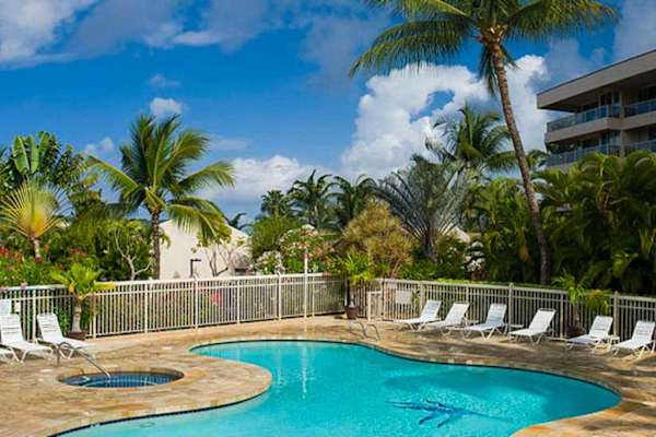 Resort pool surrounded by swaying palms and tropical greenery