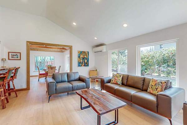 Bright living room offers comfortable seating dining access and garden views