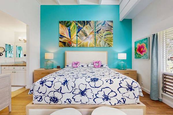 Airy bedroom presents a restful bed, soft textures, and thoughtfully arranged furnishings.