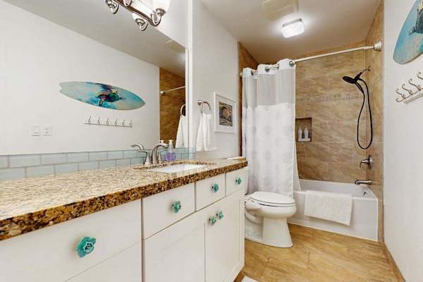 Refreshing bathroom features a modern vanity, sleek fixtures, and tiled walls throughout.
