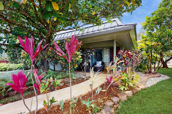 Well-kept exterior presents charming character, clear walkways, and surrounding greenery